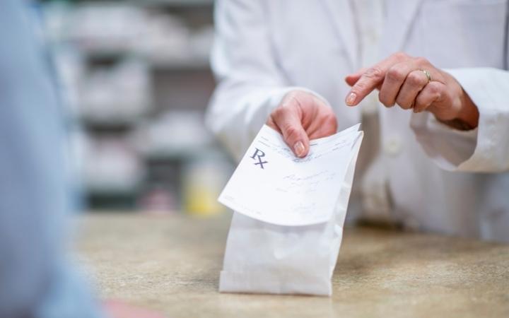 Pharmacist holding script in pharmacy