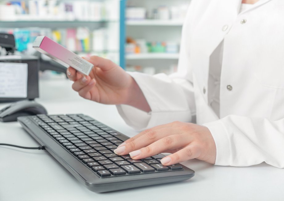 Close up of pharmacist hands processing medical cannabis product for customer on a keyboard 